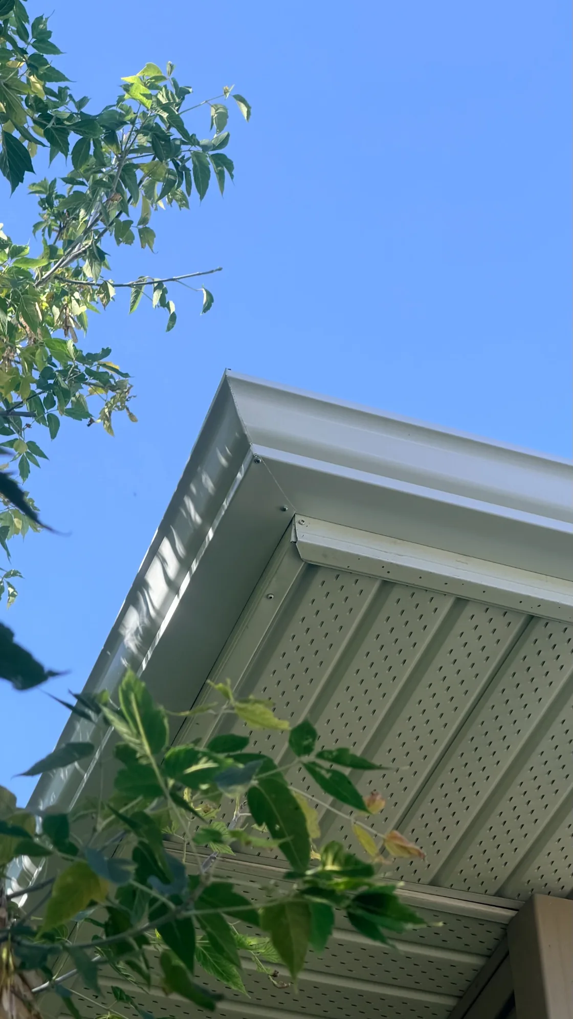 White gutter corner above fascia and vented soffit on a Regina home