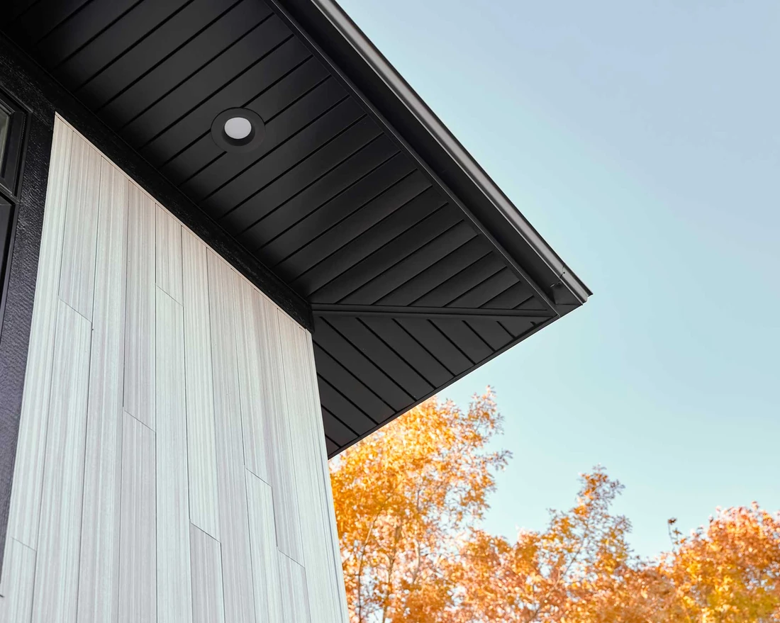 Black soffit panels with a recessed light beneath a roof overhang