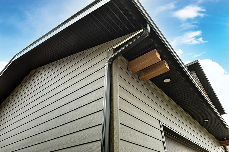 Black soffit beneath a finished roof overhang with lights and a downspout